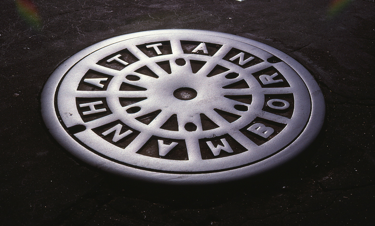 Manhole cover with Manhattan spelled out on it.