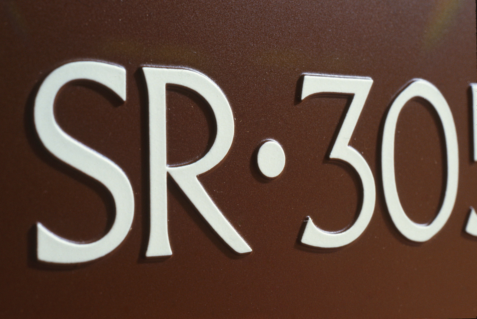 Closeup of two letters and two numbers using this font on a sign.