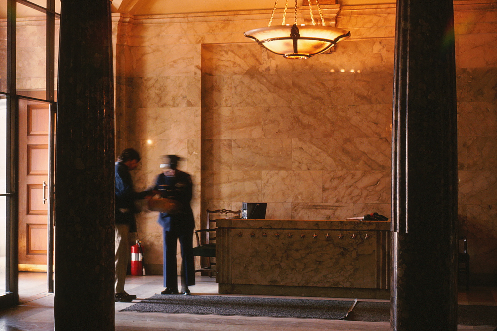 Photograph of the Capitol lobby featuring two guards and the main security desk