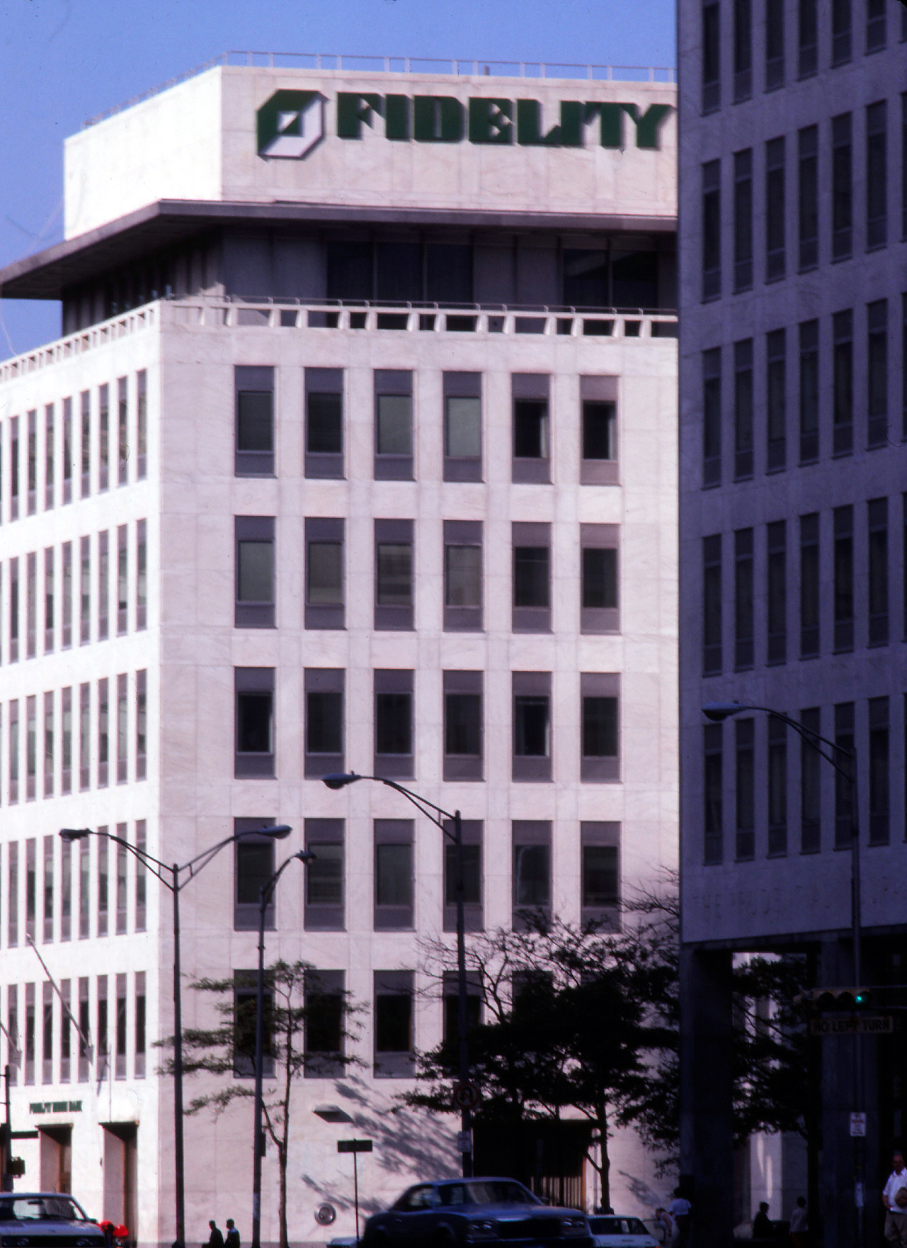 Photo of a tall white building in downtown Newark, New Jersey, with the new green logo and typeface boldly displayed atop it.