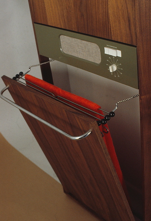 The wood paneled dryer & hamper unit shown with the door opening.