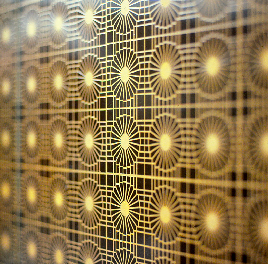 Etched elevator doors featuring repetitive symbols.