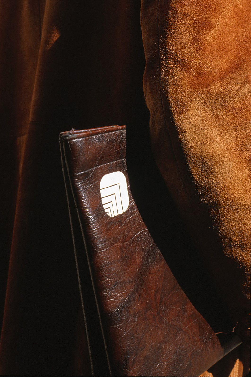 Leather folder with Oxford logo in the upper corner, tucked beneath an arm.