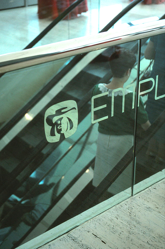 The Quaker symbol as seen through the clear glass alongside an escalator.