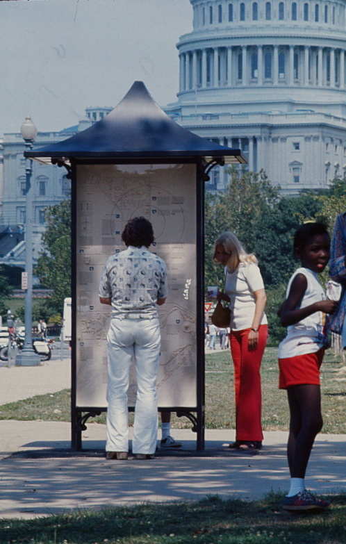 People looking at kiosk by Capitol building