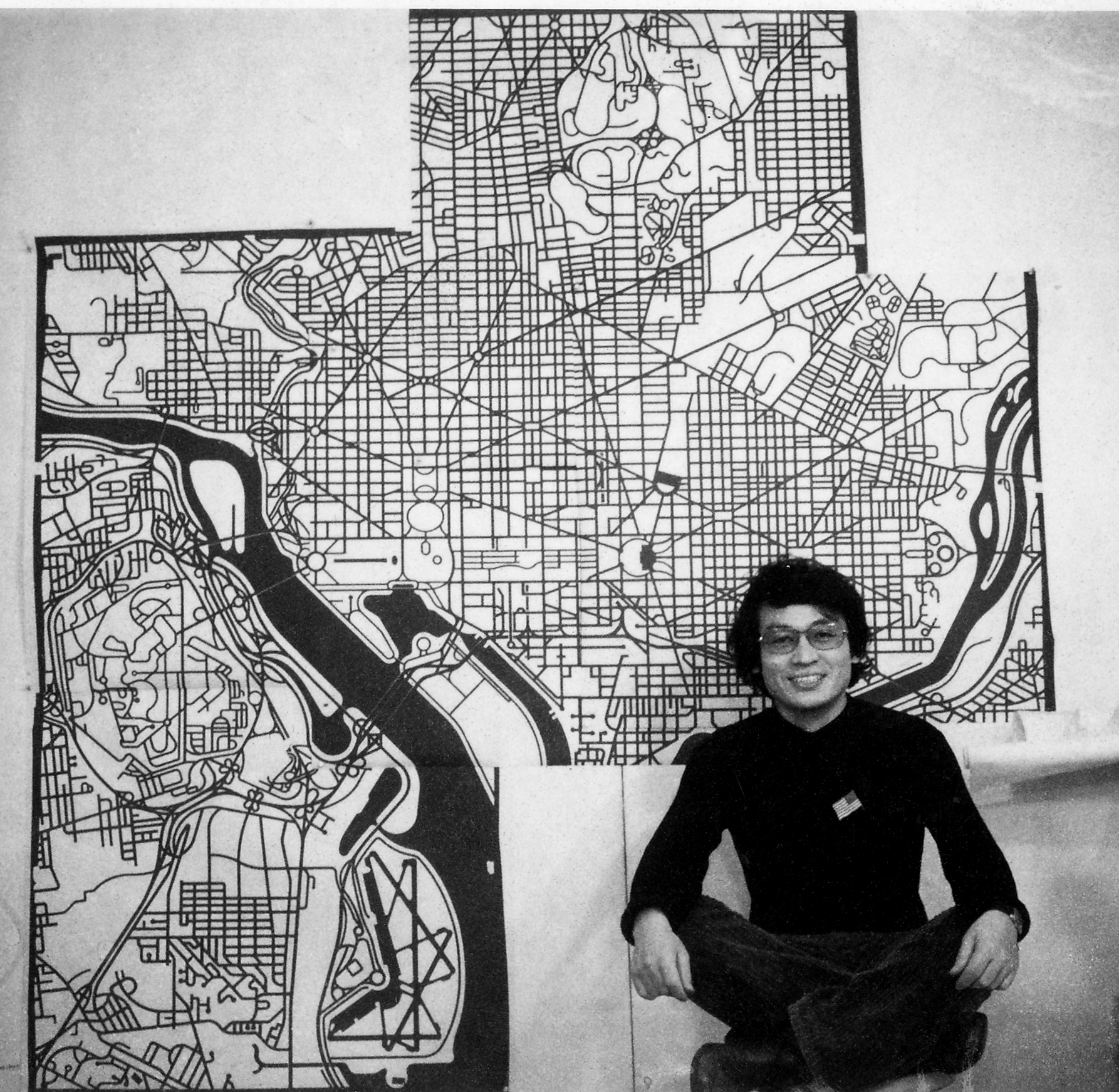 Aki sitting in front of map cutouts