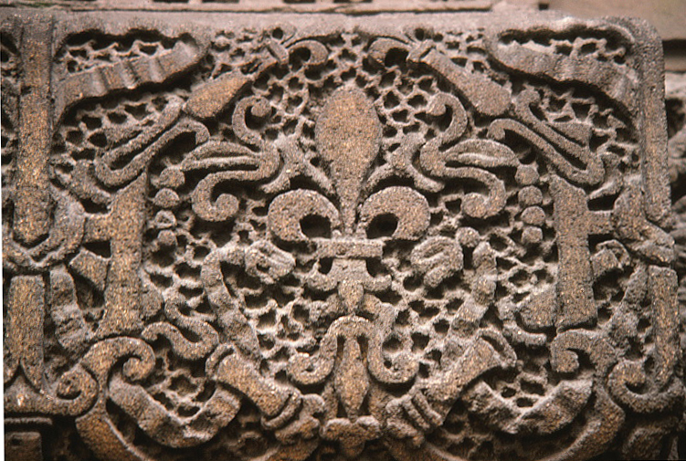 Closeup of a stone 'fleur de lis' design on an exterior wall of the Louvre.