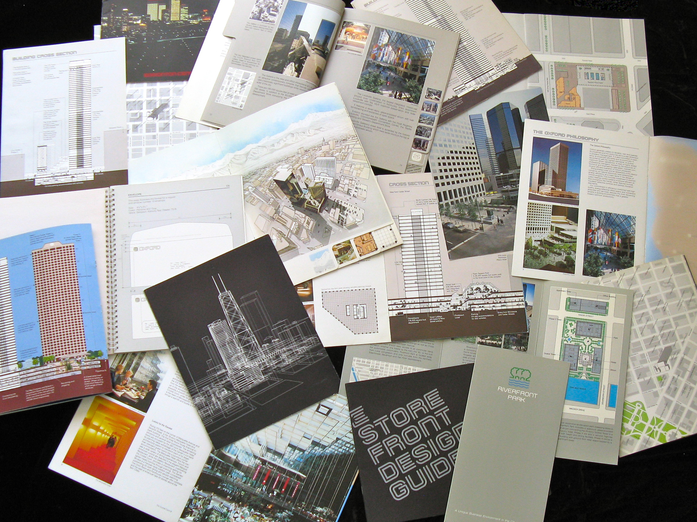 A collection of Oxford Properties brochures spread out on a table.