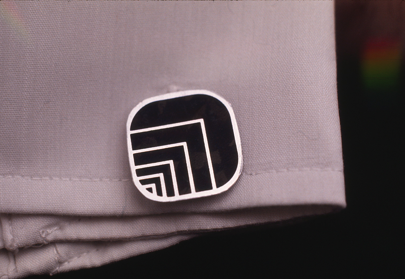 Closeup of cufflink on a sleeve featuring Oxford logo.