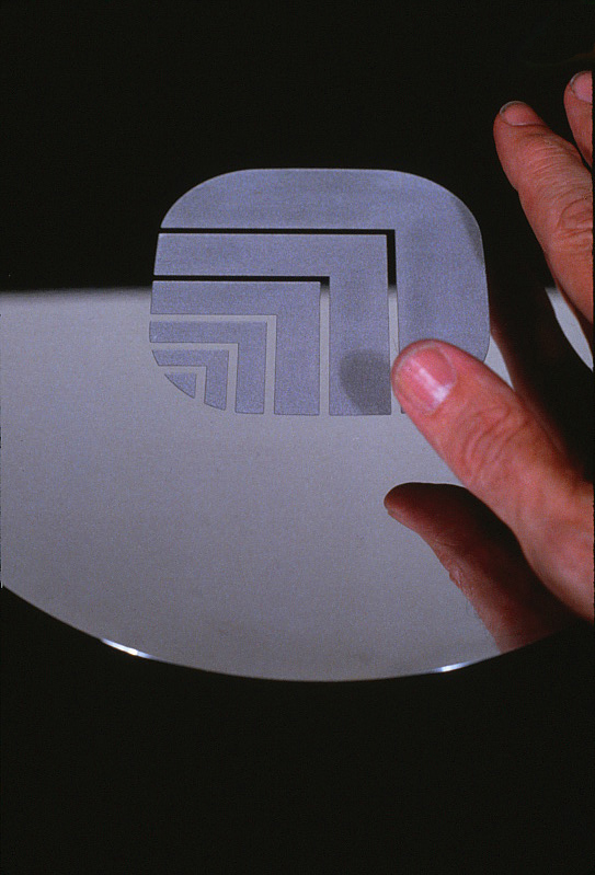 Closeup of a door pull with Oxford logo with a hand nearby.