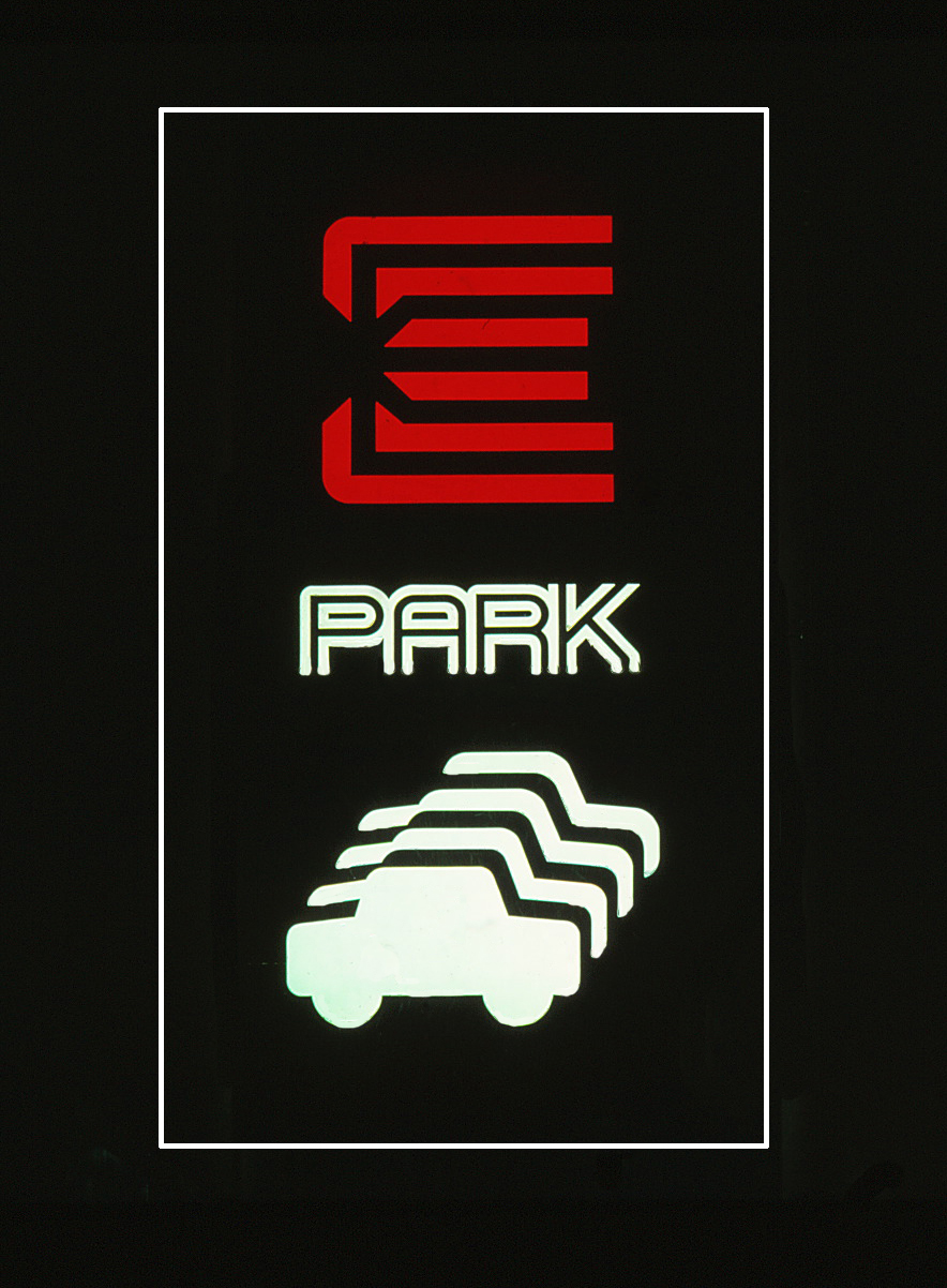 Sign for the parking garage featuring the E logo, a 'PARK' script and automobile pictograms.