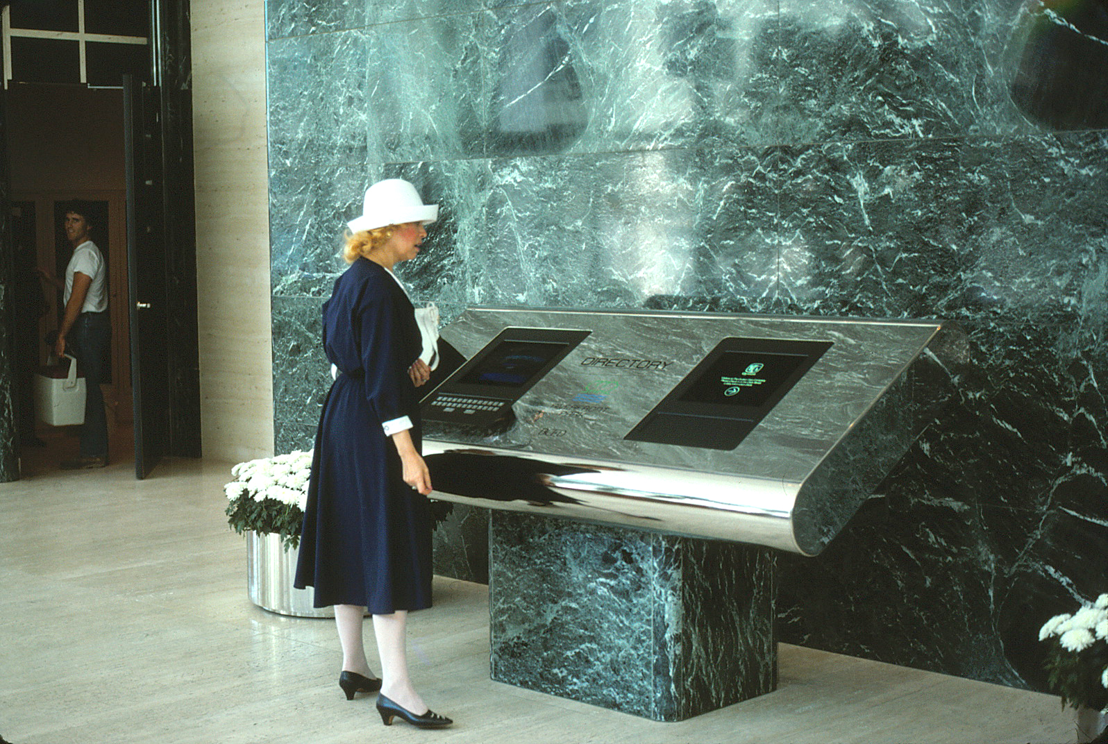 A woman using the interactive directory in the lobby of Quaker Tower.