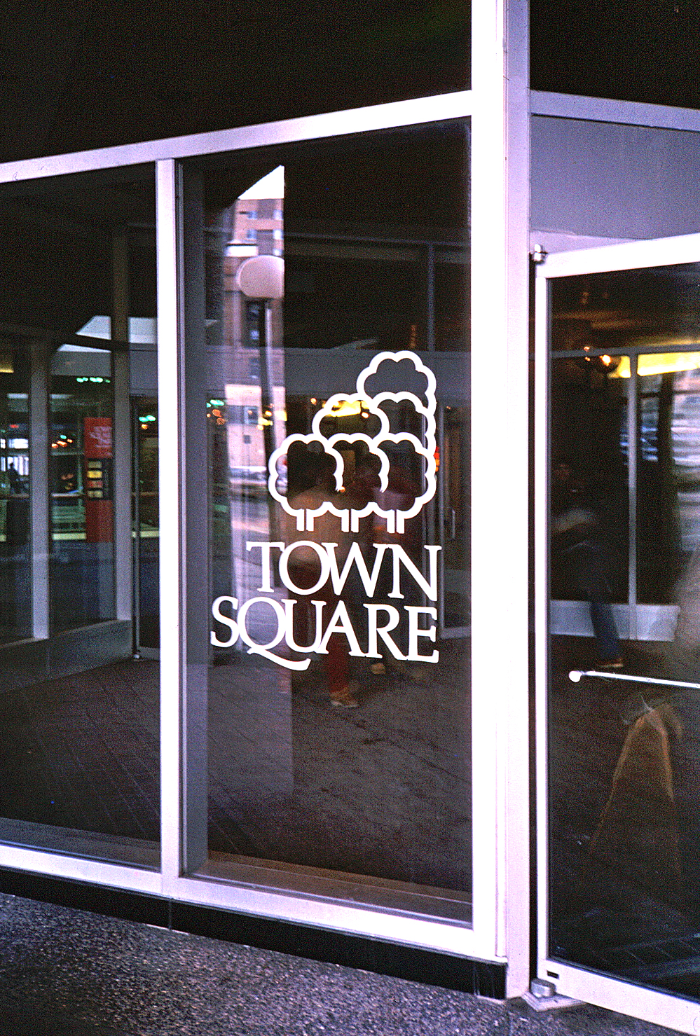 Logo and typeface signature etched on a large glass window in the public park.