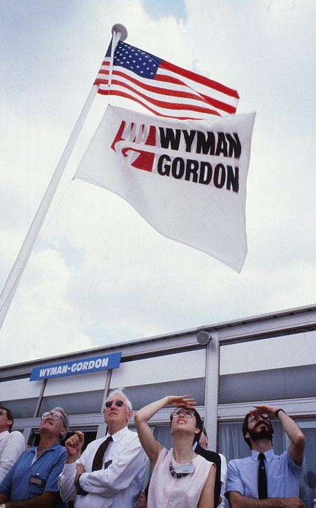 United States and Wyman-Gordon flags on a flagpole outside.